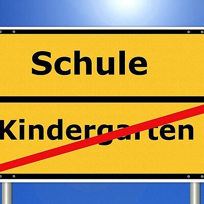 Ortsschild mit Schule und Kindergarten durchgestrichen